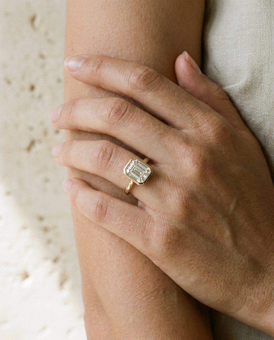The Agnes Select bezel solitaire square emerald engagement ring in 18k white gold — on hand — RockHer