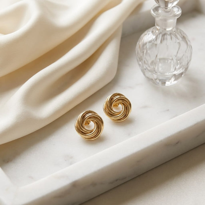 14K Yellow Gold Love Knot Stud Earrings, on marble vanity tray with silk