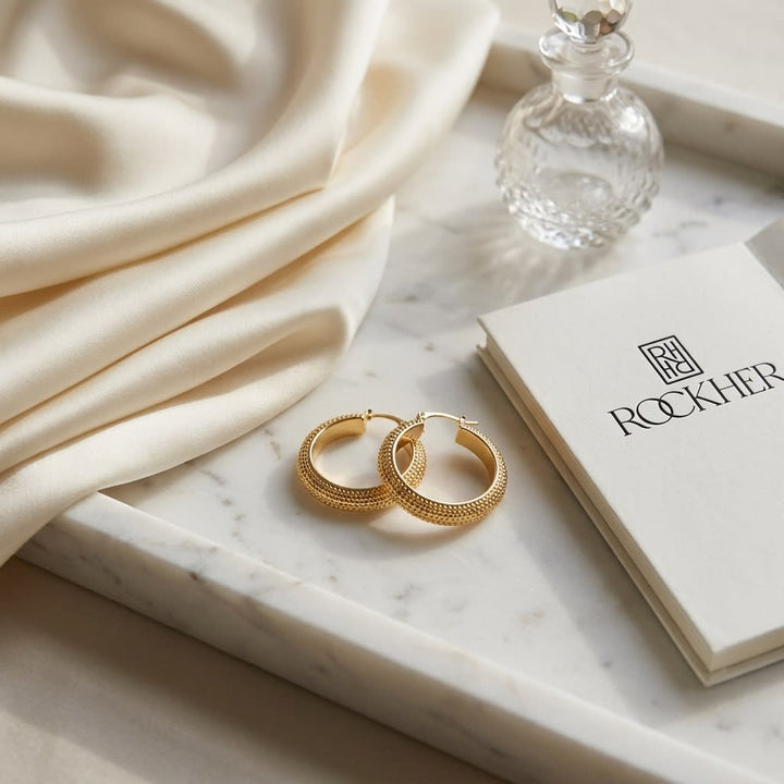 14K Yellow Gold Beaded Oval Hoop Earrings, on marble vanity tray with silk