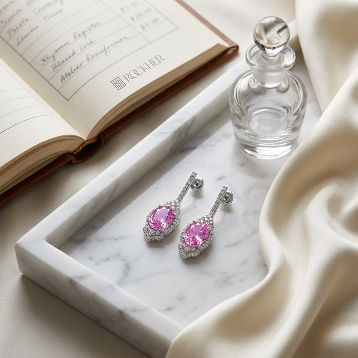 Pink Sapphire And Diamond Dangle Oval Earrings in 18K White Gold, on marble vanity tray with silk