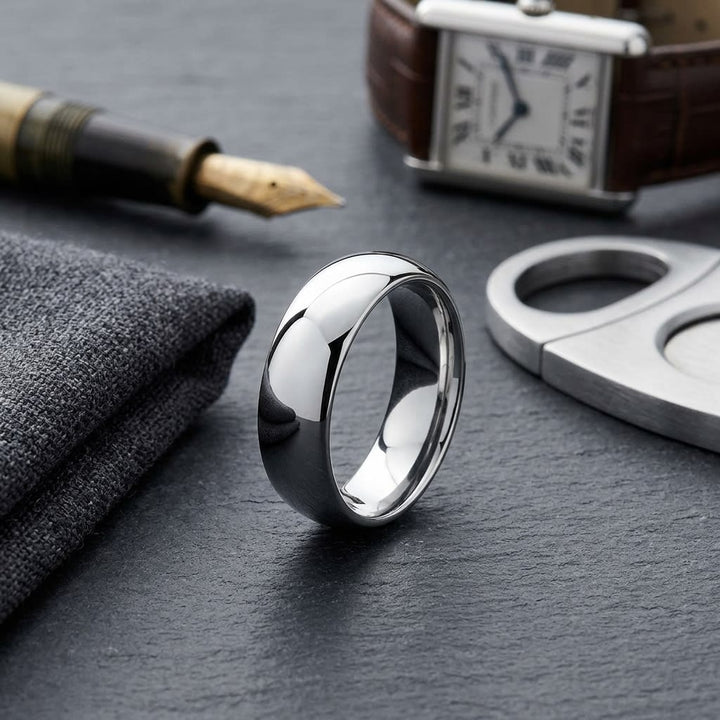 7mm High Dome Comfort-Fit Wedding Band in 18K White Gold, on walnut surface with pocket square
