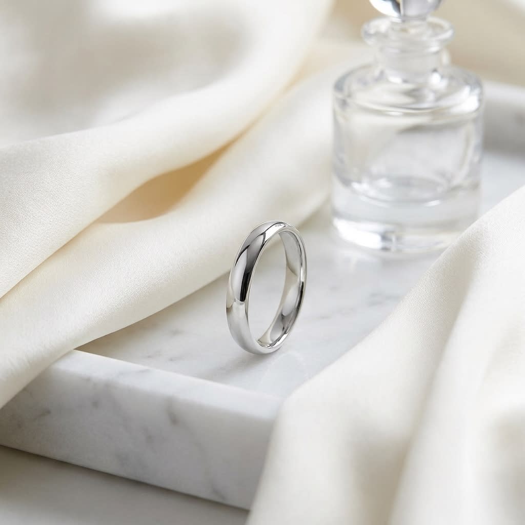 4mm Slightly Domed Comfort-Fit Wedding Band in 18K White Gold, on marble vanity tray with silk