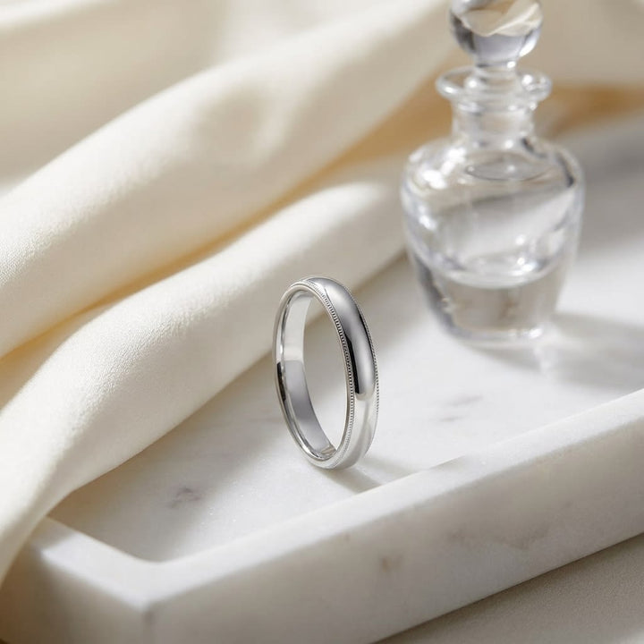 4mm Slightly Domed Double Milgrain Comfort-Fit Wedding Band in 18K White Gold, on marble vanity tray with silk