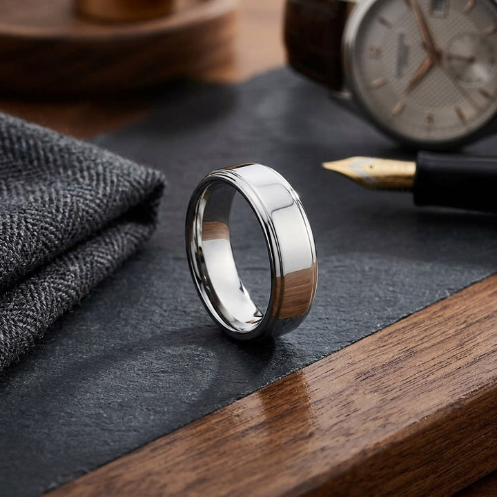 6.5mm Drop Edge High Polish Carved Wedding Band in 18K White Gold, on walnut surface with pocket square
