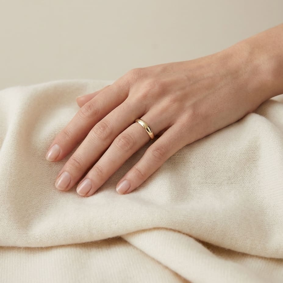 2.5mm Slightly Domed Traditional Oval Wedding Band in 18K Yellow Gold, worn on hand, full view