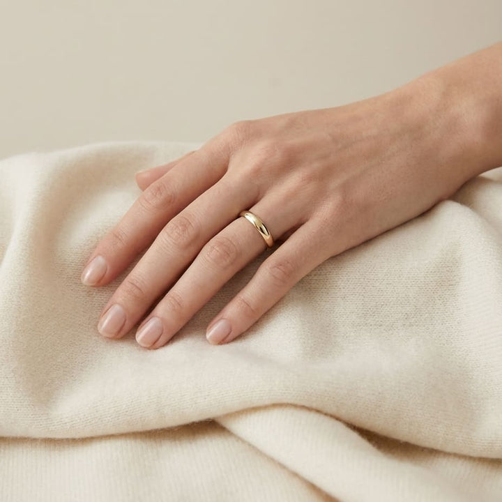 2.5mm Slightly Domed Traditional Oval Wedding Band in 18K Yellow Gold, worn on hand, full view