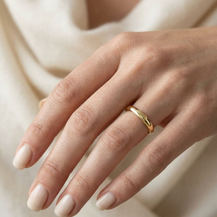 3mm Slightly Domed Traditional Oval Wedding Band in 18K Yellow Gold, worn on hand, close-up