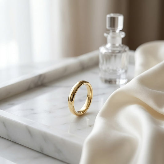 3mm Slightly Domed Traditional Oval Wedding Band in 18K Yellow Gold, on marble vanity tray with silk