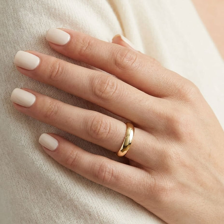4mm Slightly Domed Traditional Oval Wedding Band in 18K Yellow Gold, worn on hand, close-up