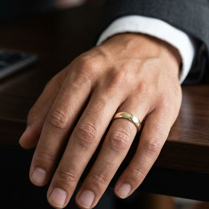 5mm Slightly Domed Traditional Oval Wedding Band in 18K Yellow Gold, worn on hand, masculine close-up