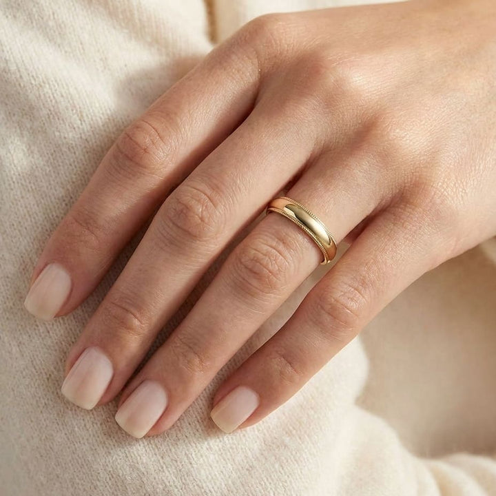 4mm Slightly Domed Traditional Oval Milgrain Wedding Band in 18K Yellow Gold, worn on hand, close-up