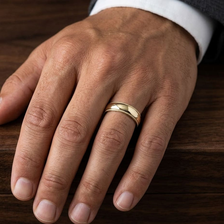 6mm Slightly Domed Traditional Oval Milgrain Wedding Band in 18K Yellow Gold, worn on hand, masculine close-up