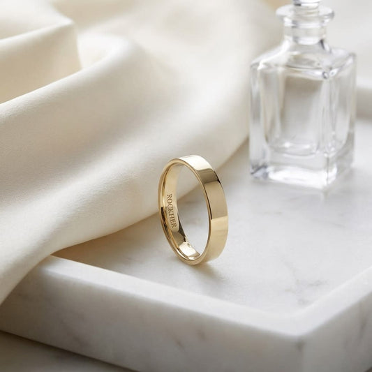 4mm Flat Comfort-Fit Wedding Band in 18K Yellow Gold, on marble vanity tray with silk