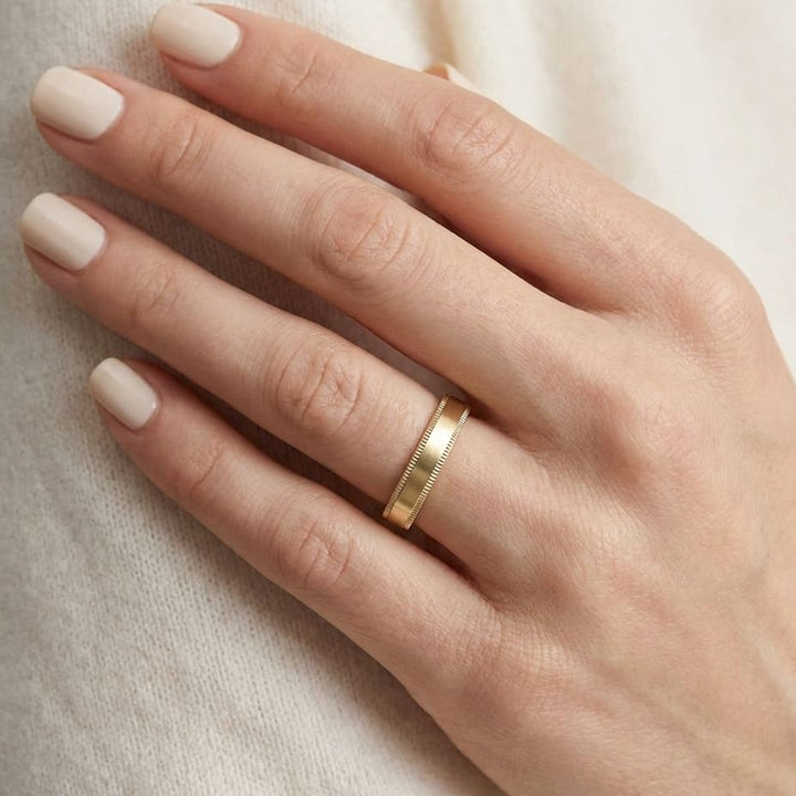 4mm Flat Milgrain Comfort-Fit Wedding Band in 18K Yellow Gold, worn on hand, close-up