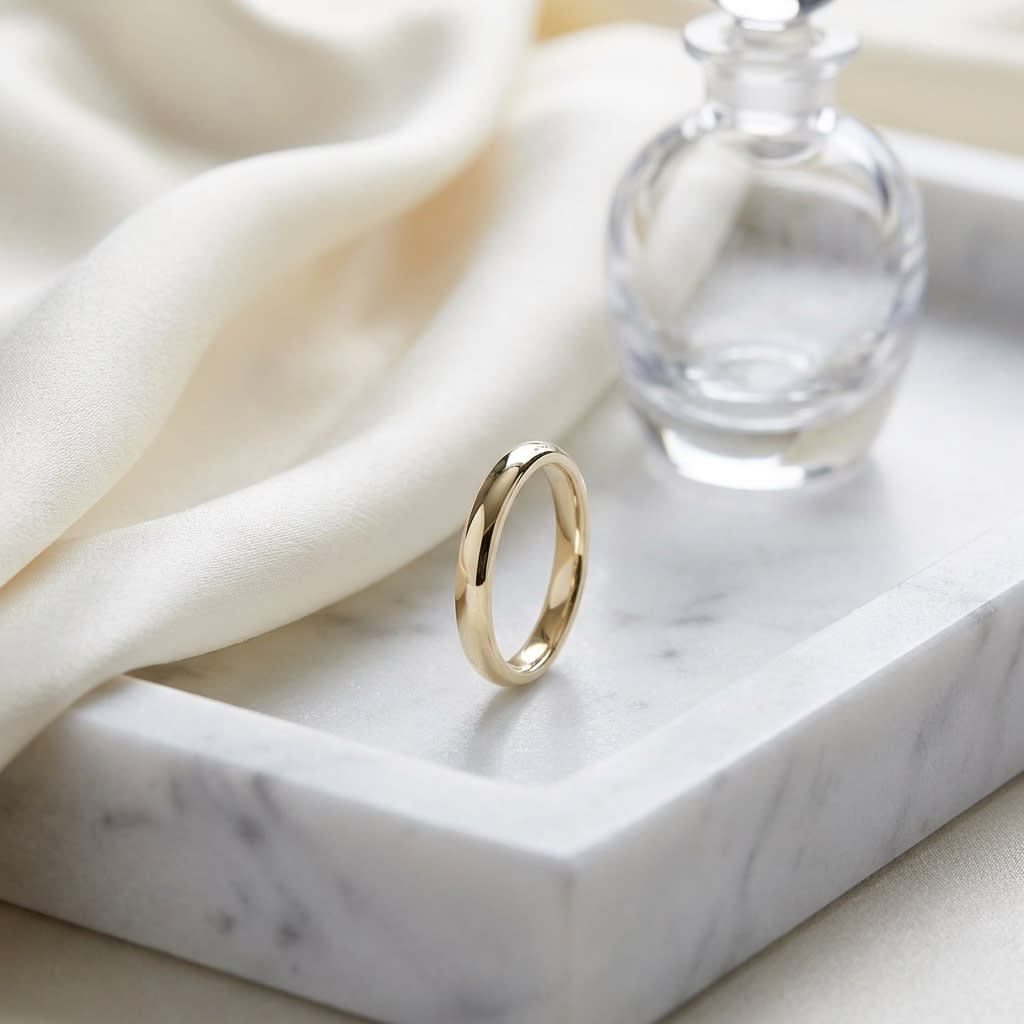 3mm Slightly Domed Comfort-Fit Wedding Band in 18K Yellow Gold, on marble vanity tray with silk
