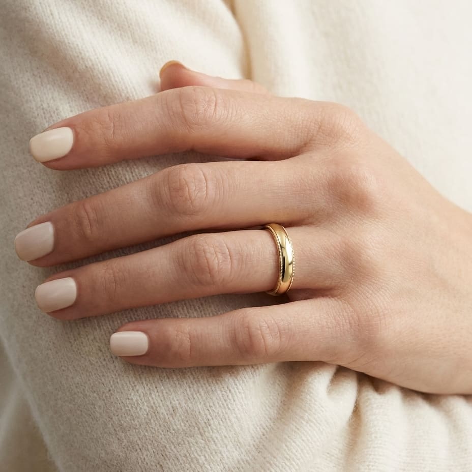 4mm Slightly Domed Milgrain Comfort-Fit Wedding Band in 18K Yellow Gold, worn on hand, close-up