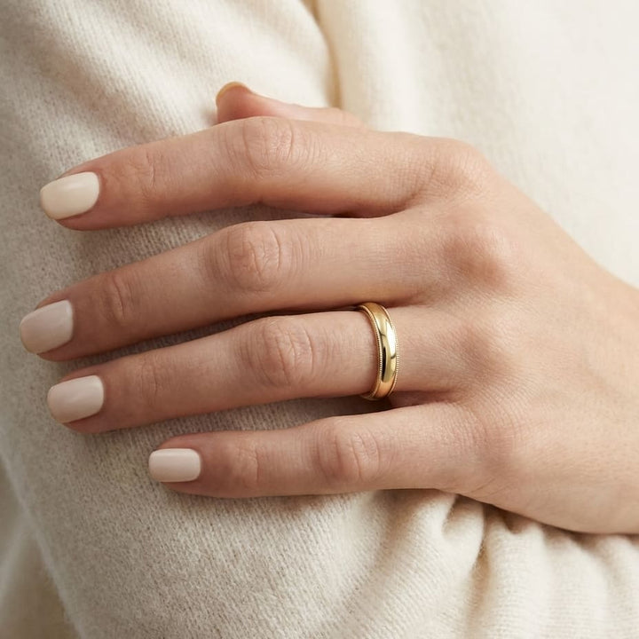 4mm Slightly Domed Milgrain Comfort-Fit Wedding Band in 18K Yellow Gold, worn on hand, close-up