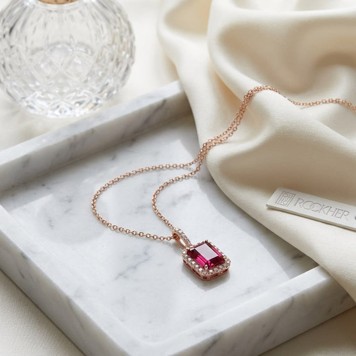 Pink Tourmaline Halo Pendant in 14K Rose Gold, on marble vanity tray with silk