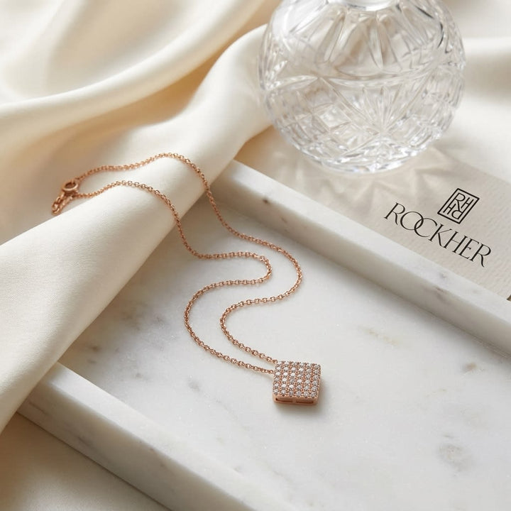 Natural Diamond Round Brilliant Pendant in 14K Rose Gold, on marble vanity tray with silk