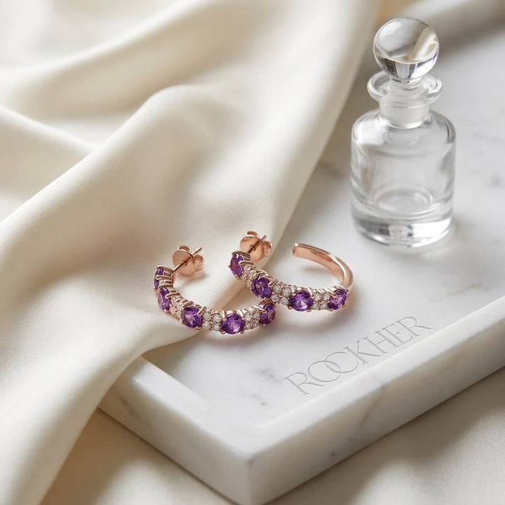 Amethyst And Diamond Alternating Prong-set 2-row Half Hoop Earring in 14K Rose Gold, on marble vanity tray with silk