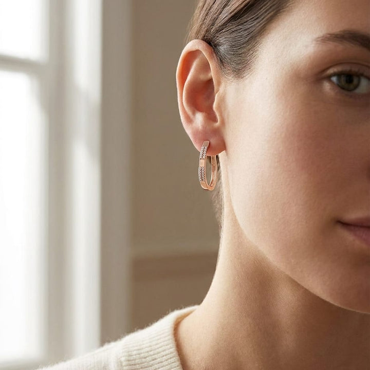 Diamond Pave Linear Oval Hoop Earrings With High Polish Accent in 14K Rose Gold, worn close-up portrait