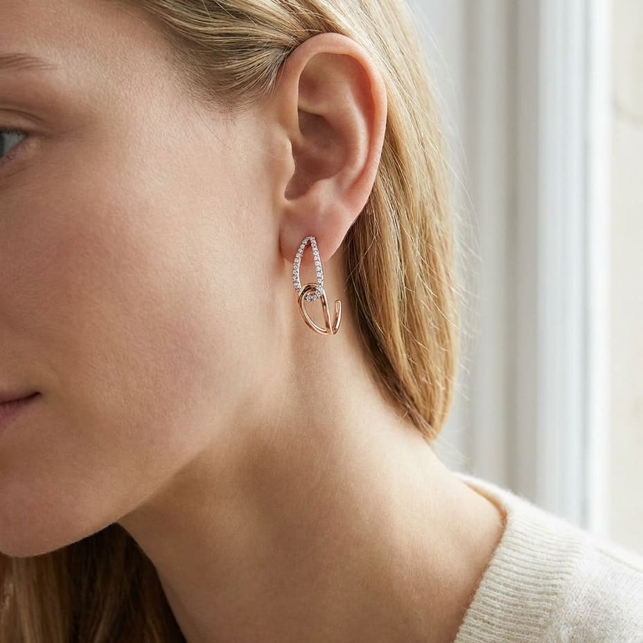 Diamond Pave And High Polish Teardrop Interlink Earrings in 14K Rose Gold, worn close-up portrait