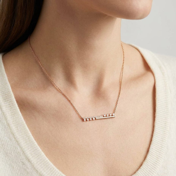 Diamond Half-bar And Pave Necklace With Prong-set Accents in 14K Rose Gold, worn close-up portrait