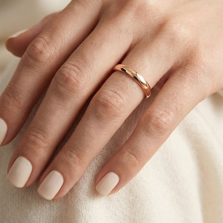 2.5mm Slightly Domed Traditional Oval Wedding Band in 14K Rose Gold, worn on hand, close-up