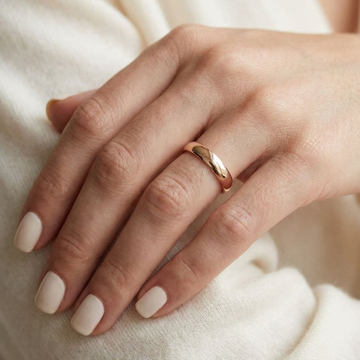 4mm Slightly Domed Traditional Oval Wedding Band in 14K Rose Gold, worn on hand, close-up