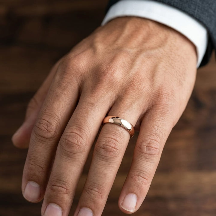 5mm Slightly Domed Traditional Oval Wedding Band in 14K Rose Gold, worn on hand, masculine close-up
