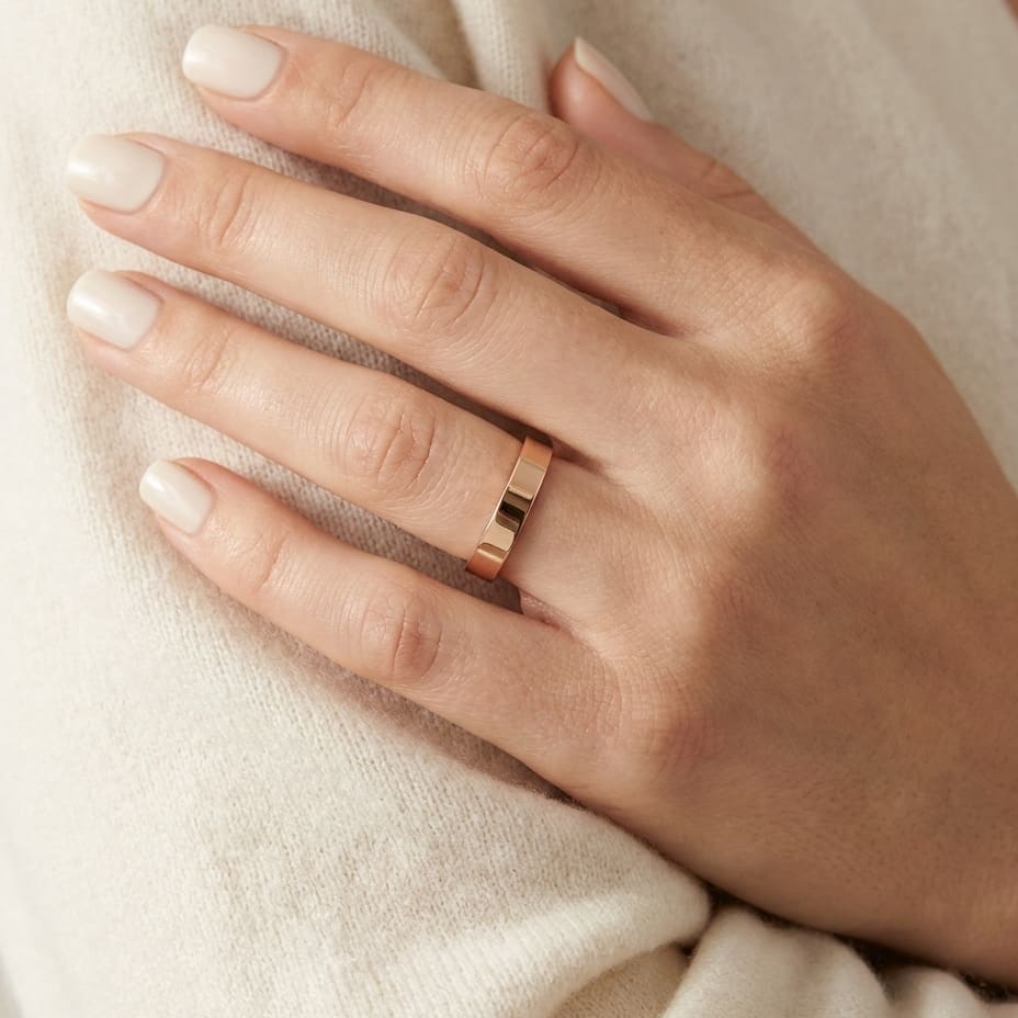 4mm Flat Comfort-Fit Wedding Band in 14K Rose Gold, worn on hand, close-up