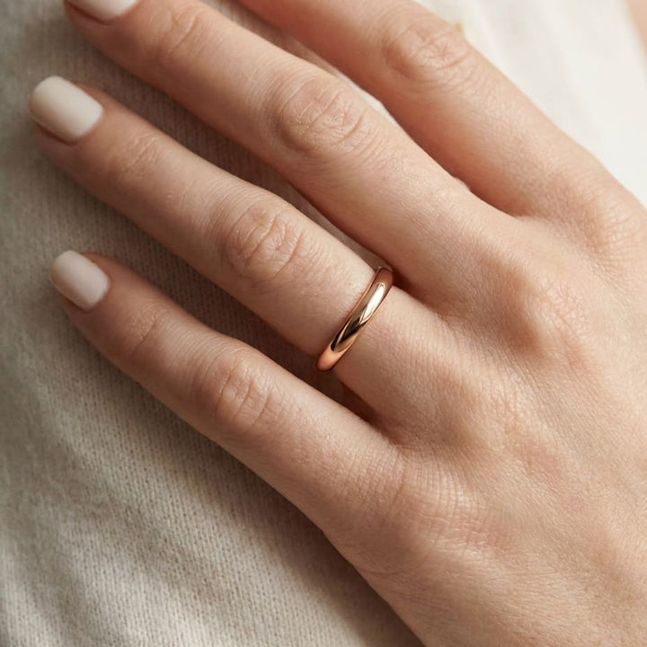 2mm Slightly Domed Comfort-Fit Wedding Band in 14K Rose Gold, worn on hand, close-up