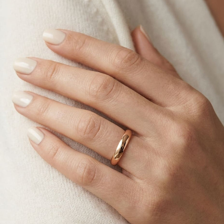 2.5mm Slightly Domed Comfort-Fit Wedding Band in 14K Rose Gold, worn on hand, close-up