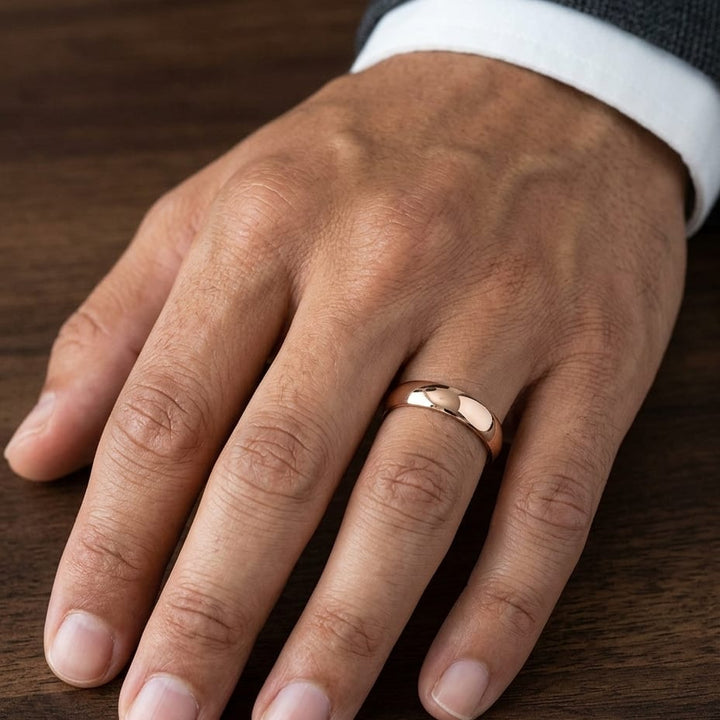 5mm Slightly Domed Comfort-Fit Wedding Band in 14K Rose Gold, worn on hand, masculine close-up