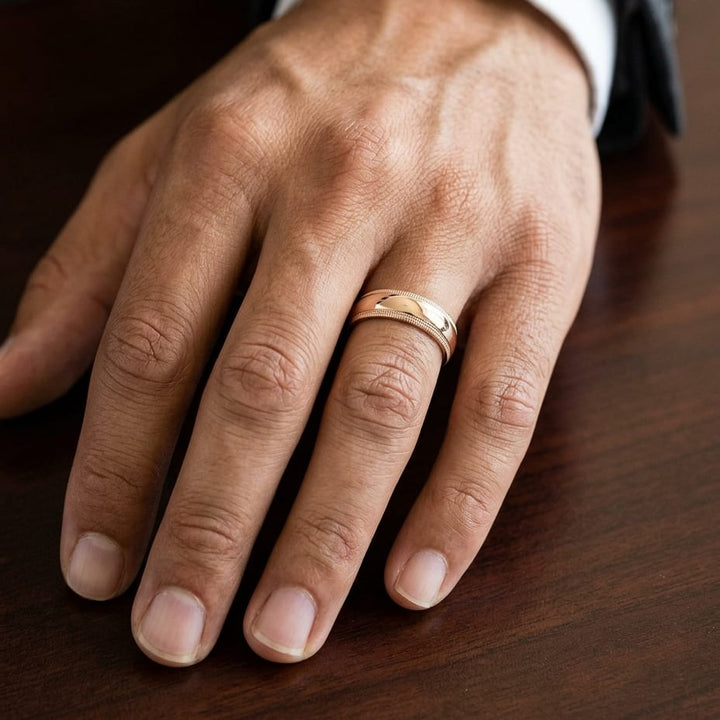 7mm Slightly Domed Double Milgrain Comfort-Fit Wedding Band in 14K Rose Gold, worn on hand, masculine close-up