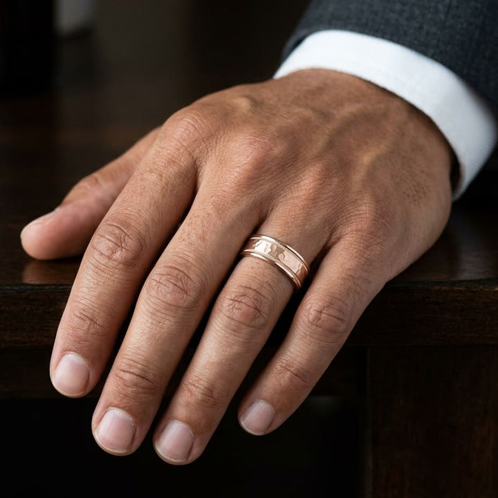 8mm Hammered Center High Polish Round Edge Carved Wedding Band in 14K Rose Gold, worn on hand, masculine close-up