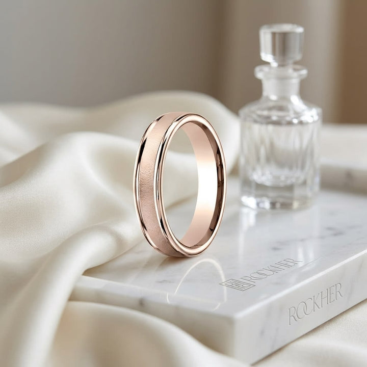 4mm Wired Finish High Polished Round Edge Carved Wedding Band in 14K Rose Gold, on marble vanity tray with silk