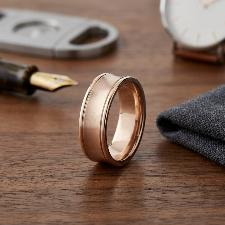 7.5mm Satin Finish High Polished Round Edge Carved Wedding Band in 14K Rose Gold, on walnut surface with pocket square