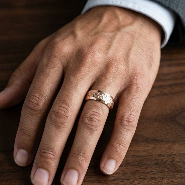 7.5mm Hammered Finish Beveled Edge Carved Wedding Band in 14K Rose Gold, worn on hand, masculine close-up