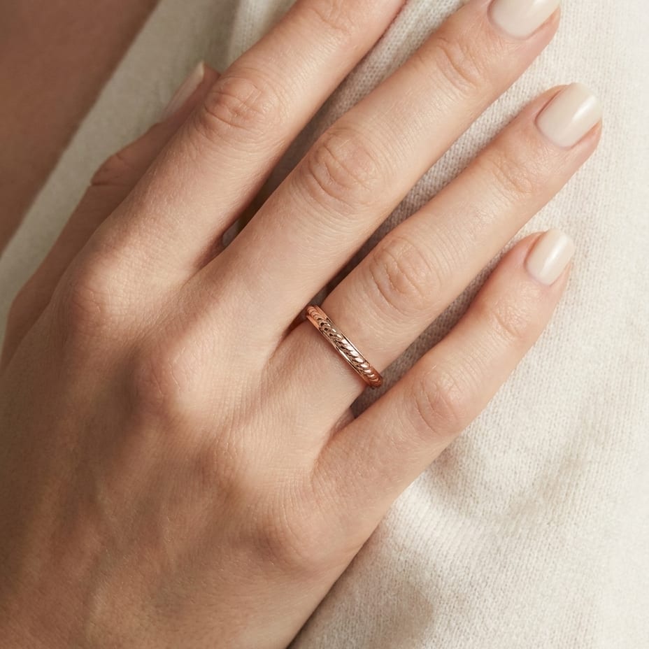 2mm High Polish Carved Wedding Band in 14K Rose Gold, worn on hand, close-up