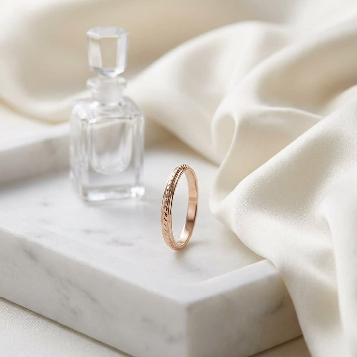 2mm High Polish Carved Wedding Band in 14K Rose Gold, on marble vanity tray with silk