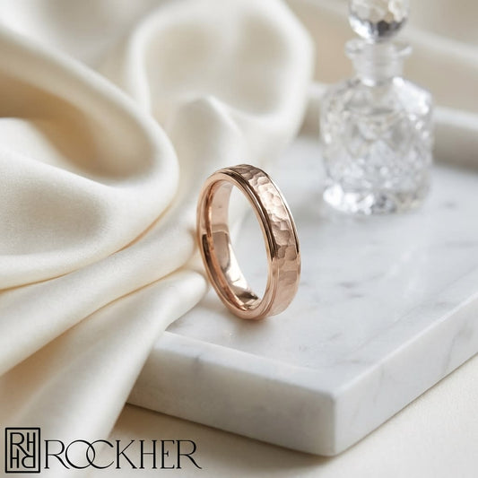 4mm Hammered Finish Carved Wedding Band in 14K Rose Gold, on marble vanity tray with silk