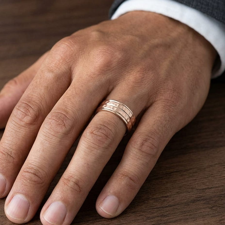 7.5mm High Polish Round Edge Carved Wedding Band in 14K Rose Gold, worn on hand, masculine close-up