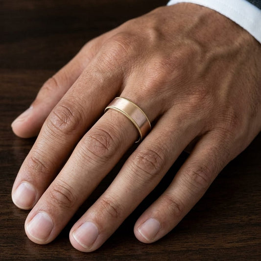 8mm Satin Finish Carved Wedding Band in 14K Rose Gold, worn on hand, masculine close-up
