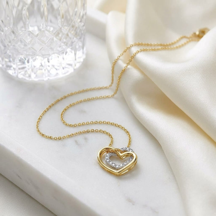 Diamond Pave Double Heart Pendant In Two Tone 14k Gold, on marble vanity tray with silk