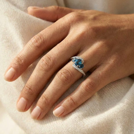 London Blue Topaz Three Stone Swirl Ring in 14k White Gold 0.13ctw, worn on hand, close-up