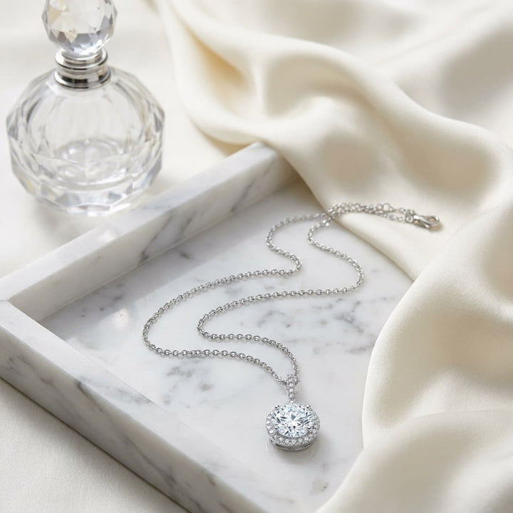 Natural Diamond Round Brilliant Halo Pendant in 14K White Gold, 1 ct. t.w., on marble vanity tray with silk