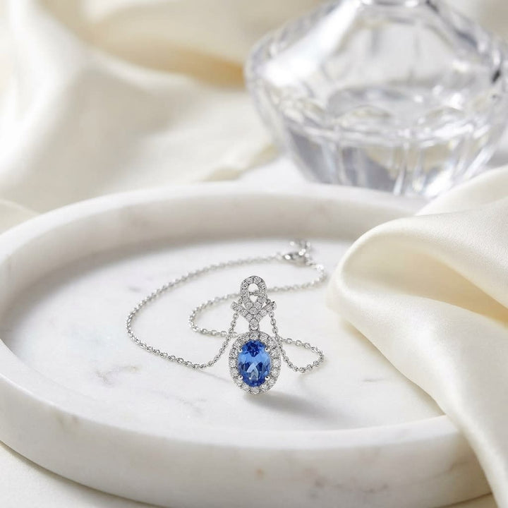 Tanzanite Oval Halo Pendant in 14K White Gold, on marble vanity tray with silk