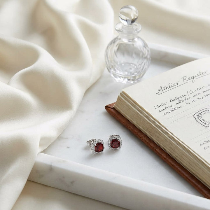 Garnet And Diamond Cushion Halo Earrings In 14k White Gold, on marble vanity tray with silk