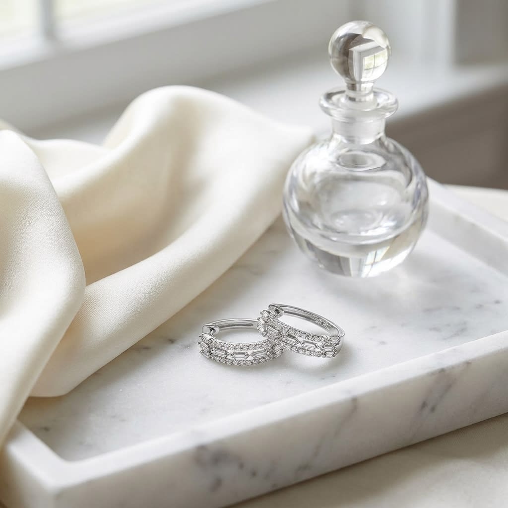 Diamond Baguette And Round Brilliant Multi-row Oval Hinged Hoop Earring in 14K White Gold, on marble vanity tray with silk